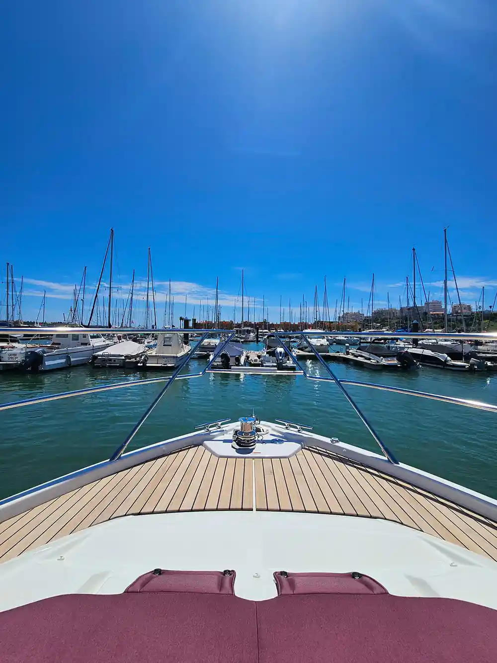 The bow of the yacht in the marina among moored boats