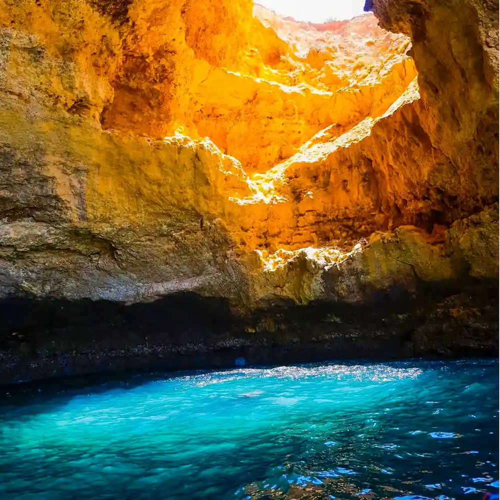 A glowing orange chamber above brilliant turquoise water