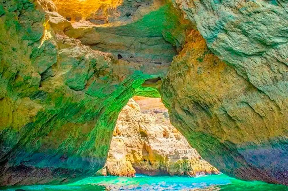 Green algae on rock above bright turquoise water in a cave