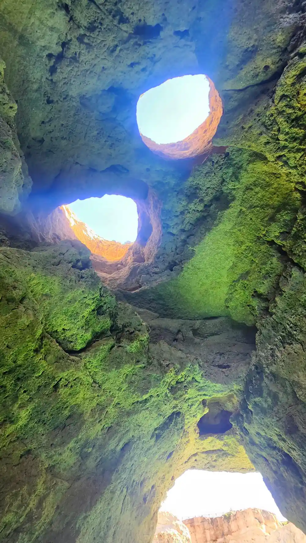 Green and orange rock around the roof opening seen from inside