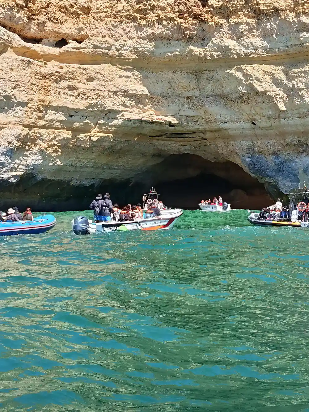 Several small boats gathered at the entrance to the cave
