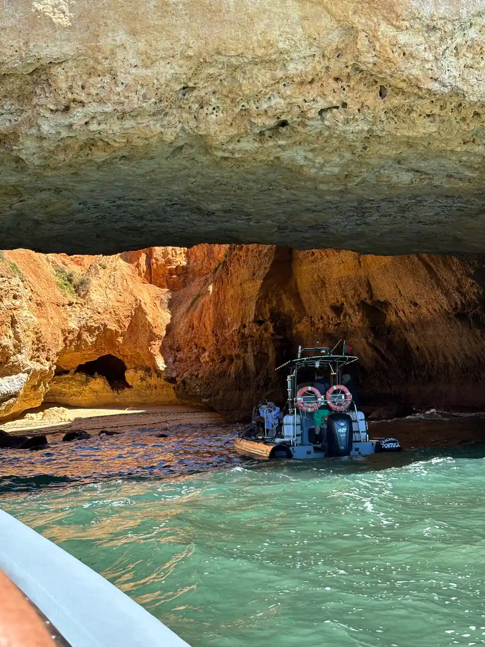 A small boat inside the cave beside the sandy floor