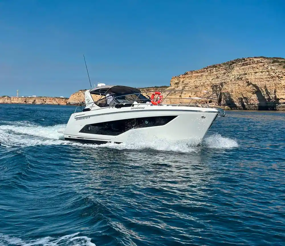 The yacht running past a headland on open water