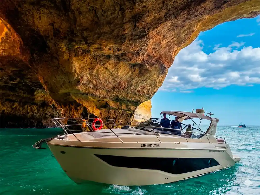 The yacht seen from below the overhang with passengers aboard